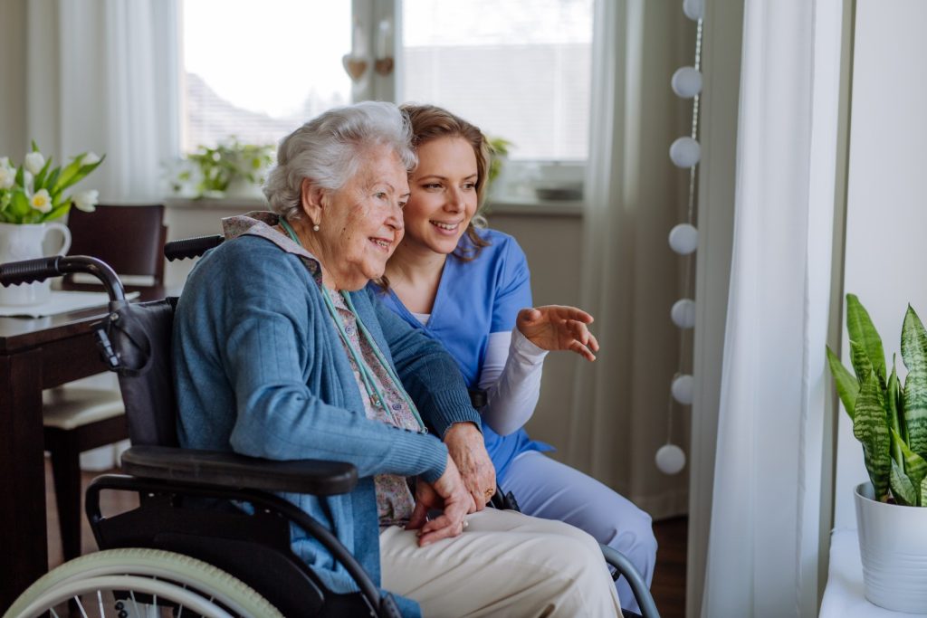 portrait-of-nurse-and-her-senior-client-on-wheelch-2024-10-18-09-08-29-utc-large